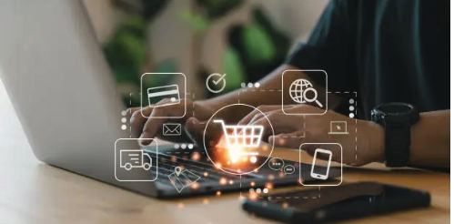 Hands typing on a laptop with digital commerce and email icons