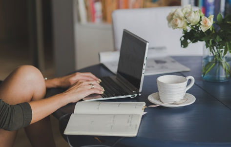 Professional workspace with laptop, notebook, and coffee
